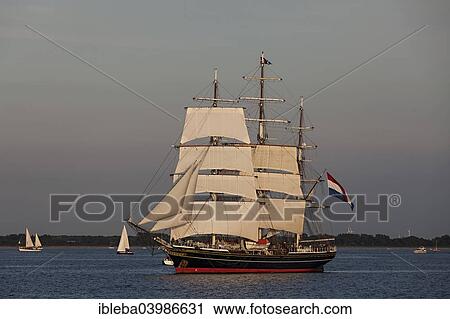 Stock Image - "Evening sailing with the Stad Amsterdam in the foreground, Hanse Sail 2014 Warnemunde, Mecklenburg-Western Pomerania, Germany, Europe". Fotosearch