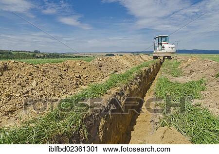 "Excavator digging a ditch through agriculture landscape, Laurich, Saxony, Germany, Europe" View Large Photo Image Stock Image - "Excavator digging a ditch through agriculture landscape, Laurich, Saxony, Germany, Europe". Fotosearch