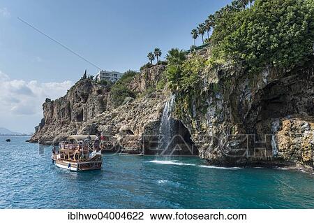 "Excursion boat in the Gulf of Antalya, cliffs with waterfall, Yavuz Ozcan Park at the top, Antalya, Turkish Adriatic, Turkey, Asia" View Large Photo Image Stock Image - "Excursion boat in the Gulf of Antalya, cliffs with waterfall, Yavuz Ozcan Park at the top, Antalya, Turkish Adriatic, Turkey, Asia". Fotosearch