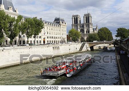 Stock Image - "Excursion boat on Seine river, Notre-Dame de Paris cathedral at back, Paris, Seine, France, Europe". Fotosearch