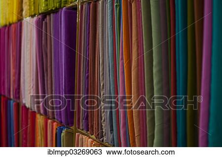 Stock Image - "Fabrics lined up on a rack, Varkala, Kerala, India, Asia". Fotosearch