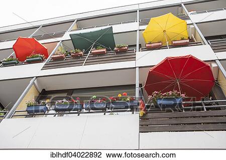 Stock Image - "Facade with balconies with flower-boxes and parasols, Linden, Hanover, Lower Saxony, Germany, Europe". Fotosearch