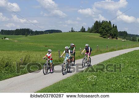 Stock Photo - "Family on a bicycle tour, in Seeweiler, Seeg Ostallgaeu, Swabia, Bavaria, Germany, Europe". Fotosearch