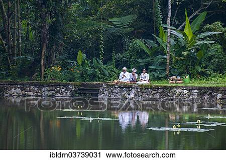 Stock Image - "Family performing religious rituals at a temple, Ubud, Bali, Indonesia, Asia". Fotosearch