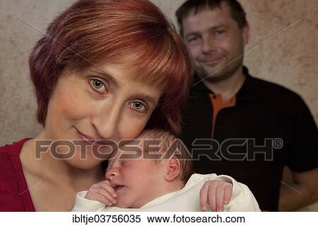 "Family portrait, mother holding her newborn baby boy, father at back, Germany, Europe" View Large Photo Image Stock Photography - "Family portrait, mother holding her newborn baby boy, father at back, Germany, Europe". Fotosearch