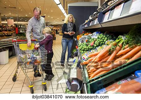 "Family shopping with a shopping trolley in the fruit and vegetables department of a supermarket, Germany, Europe" View Large Photo Image Stock Image - "Family shopping with a shopping trolley in the fruit and vegetables department of a supermarket, Germany, Europe". Fotosearch