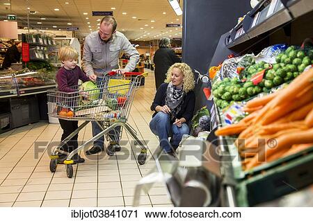 "Family shopping with a shopping trolley in the fruit and vegetables department of a supermarket, Germany, Europe" View Large Photo Image Stock Image - "Family shopping with a shopping trolley in the fruit and vegetables department of a supermarket, Germany, Europe". Fotosearch