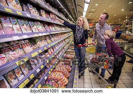 "Family shopping with a shopping trolley in the refrigerated section of a supermarket with packed meat, Germany, Europe" View Large Photo Image Stock Image - "Family shopping with a shopping trolley in the refrigerated section of a supermarket with packed meat, Germany, Europe". Fotosearch