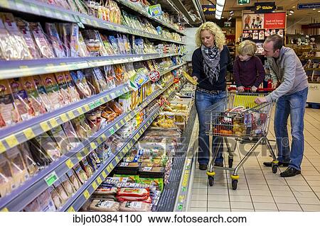 "Family shopping with a shopping trolley in the refrigerated section of a supermarket with packed meat, Germany, Europe" View Large Photo Image Stock Image - "Family shopping with a shopping trolley in the refrigerated section of a supermarket with packed meat, Germany, Europe". Fotosearch