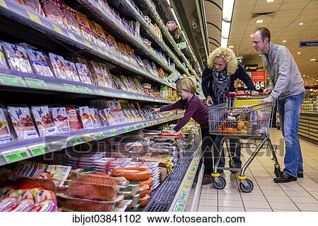 "Family shopping with a shopping trolley in the refrigerated section of a supermarket with packed meat, Germany, Europe" View Large Photo Image Stock Image - "Family shopping with a shopping trolley in the refrigerated section of a supermarket with packed meat, Germany, Europe". Fotosearch