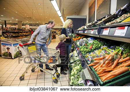 "Family shopping with a shopping trolley in the fruit and vegetables department of a supermarket, Germany, Europe" View Large Photo Image Stock Photo - "Family shopping with a shopping trolley in the fruit and vegetables department of a supermarket, Germany, Europe". Fotosearch