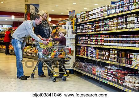 "Family shopping with a shopping trolley in a supermarket, aisle with various foodstuffs, Germany, Europe" View Large Photo Image Stock Photograph - "Family shopping with a shopping trolley in a supermarket, aisle with various foodstuffs, Germany, Europe". Fotosearch
