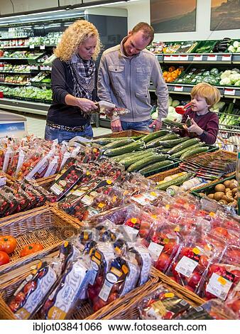 Stock Photograph - "Family shopping with a shopping trolley in the fruit and vegetables department of a supermarket, Germany, Europe". Fotosearch
