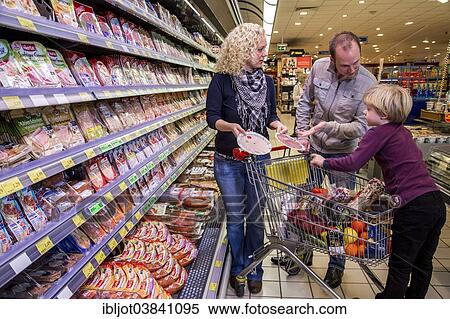 "Family shopping with a shopping trolley in the refrigerated section of a supermarket with packed meat, Germany, Europe" View Large Photo Image Stock Photography - "Family shopping with a shopping trolley in the refrigerated section of a supermarket with packed meat, Germany, Europe". Fotosearch