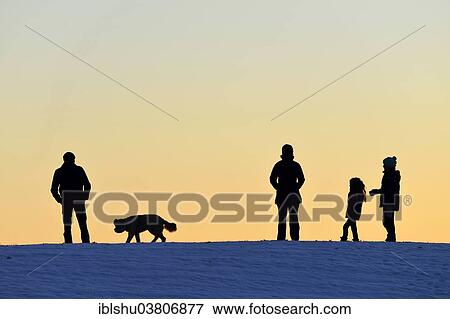 Stock Photo - "Family with dog, silhouette in the light of the setting sun, Horben, Canton Aargau, Switzerland, Europe". Fotosearch