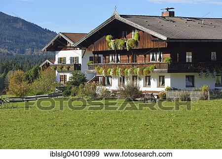 "Farmhouse in the Bavarian style with wooden top, balcony with floral decorations in Fischbachau, Leitzachtal, Bavaria, Germany, Europe" View Large Photo Image Stock Photo - "Farmhouse in the Bavarian style with wooden top, balcony with floral decorations in Fischbachau, Leitzachtal, Bavaria, Germany, Europe". Fotosearch