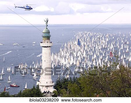 Stock Photo - "Faro della Vittoria lighthouse, sailing boats taking part in the historic sailing regatta Barcolana at back, Trieste, Province of Trieste, Friuli-Venezia Giulia, Italy, Europe". Fotosearch