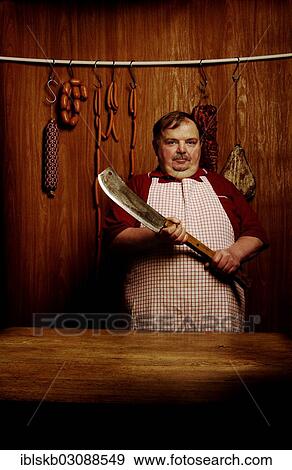 Fat butcher holding a meat cleaver in a butcher's store with a wooden ambience View Large Photo Image Stock Photo - Fat butcher holding a meat cleaver in a butcher's store with a wooden ambience. Fotosearch