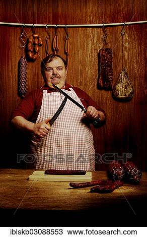 Fat butcher sharpening a filleting knife in a butcher's store with a wooden ambience View Large Photo Image Stock Image - Fat butcher sharpening a filleting knife in a butcher's store with a wooden ambience. Fotosearch