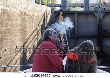 Stock Photography - "Father and daughter in the lock chamber while rising in a lock, father smoking a pipe, houseboat on the Canal des Vosges, formerly Canal de l'Est, Lock 24 at PK 114, Thunimont, Epinal, Lorraine, Departement Vosges, France, Europe". Fotosearch