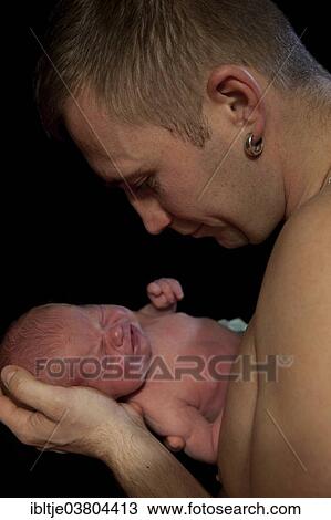 Father holding a baby in his arms View Large Photo Image Stock Image - Father holding a baby in his arms. Fotosearch