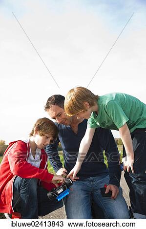 Father tinkering on a remote-controlled model car with his sons View Large Photo Image Stock Image - Father tinkering on a remote-controlled model car with his sons. Fotosearch