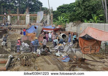 Stock Image - "Female and male construction workers on a high rise construction site, Mandalay, Myanmar, Asia". Fotosearch