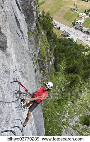 Stock Photo - "Female climber on the fixed rope route """"Via ferrata d'Evolene Region"""", Evolene, Canton of Valais, Switzerland, Europe". Fotosearch