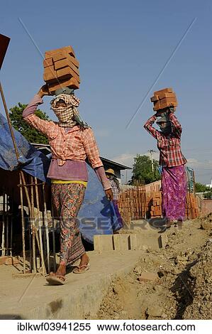 "Female construction workers carry bricks on their heads, high rise construction site, Mandalay, Myanmar, Asia" View Large Photo Image Stock Photography - "Female construction workers carry bricks on their heads, high rise construction site, Mandalay, Myanmar, Asia". Fotosearch