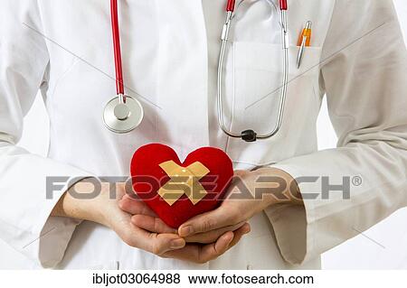 "Female doctor holding a red heart with a plaster in her hands, symbolic image for a heart attack" View Large Photo Image Stock Photo - "Female doctor holding a red heart with a plaster in her hands, symbolic image for a heart attack". Fotosearch
