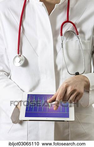 "Female doctor holding a tablet computer, iPad, with an ECG graph" View Large Photo Image Stock Image - "Female doctor holding a tablet computer, iPad, with an ECG graph". Fotosearch