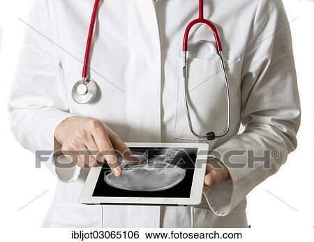 "Female doctor holding a tablet computer, iPad, with an X-ray of a human head" View Large Photo Image Stock Photograph - "Female doctor holding a tablet computer, iPad, with an X-ray of a human head". Fotosearch