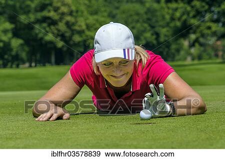 "Female golfer flicking the golf ball with her fingers into the hole, Golfclub Schloss Myllendonk, Korschenbroich, North Rhine-Westphalia, Germany, Europe" View Large Photo Image Stock Photo - "Female golfer flicking the golf ball with her fingers into the hole, Golfclub Schloss Myllendonk, Korschenbroich, North Rhine-Westphalia, Germany, Europe". Fotosearch