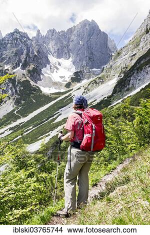 Picture - "Female hiker looking towards the Wilder Kaiser Mountains from the Wilder-Kaiser-Steig hiking trail, Kaisergebirge, near Ellmau, Tyrol, Austria, Europe". Fotosearch