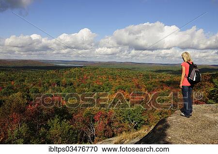 "Female hiker standing on a rock overlooking a colourful autumnal forest, Algonquin Provincial Park, Ontario Province, Canada, North America" View Large Photo Image Stock Image - "Female hiker standing on a rock overlooking a colourful autumnal forest, Algonquin Provincial Park, Ontario Province, Canada, North America". Fotosearch