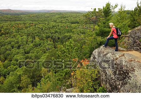 "Female hiker standing on a rock overlooking woodlands, Algonquin Provincial Park, Ontario Province, Canada, North America" View Large Photo Image Stock Image - "Female hiker standing on a rock overlooking woodlands, Algonquin Provincial Park, Ontario Province, Canada, North America". Fotosearch