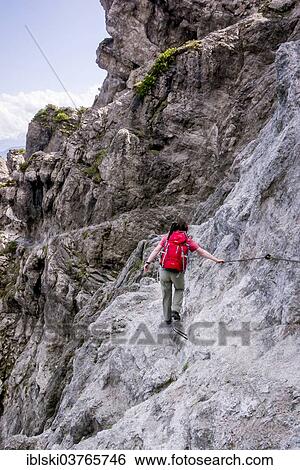 "Female hiker walking along the fixed cable route of Jubilaeumssteig, a section on the Wilder-Kaiser-Steig hiking trail, Kaisergebirge, near Ellmau, Tyrol, Austria, Europe" View Large Photo Image Stock Photograph - "Female hiker walking along the fixed cable route of Jubilaeumssteig, a section on the Wilder-Kaiser-Steig hiking trail, Kaisergebirge, near Ellmau, Tyrol, Austria, Europe". Fotosearch