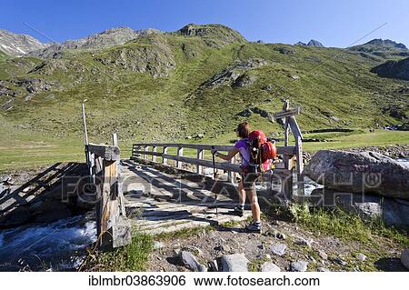 "Female mountain climber at Timmelsalm alpine pasture crossing Timmlserbach stream, during the ascent to Muller Hut through the Passeiertal valley along the Timmelsjoch pass route, Alto Adige, Italy, Europe" View Large Photo Image Stock Photograph - "Female mountain climber at Timmelsalm alpine pasture crossing Timmlserbach stream, during the ascent to Muller Hut through the Passeiertal valley along the Timmelsjoch pass route, Alto Adige, Italy, Europe". Fotosearch