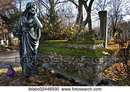 "Female statue beside a mossy sarcophagus with autumn leaves on the Ostfriedhof or East Cemetery, Munich, Bavaria, Germany, Europe" View Large Photo Image Stock Image - "Female statue beside a mossy sarcophagus with autumn leaves on the Ostfriedhof or East Cemetery, Munich, Bavaria, Germany, Europe". Fotosearch