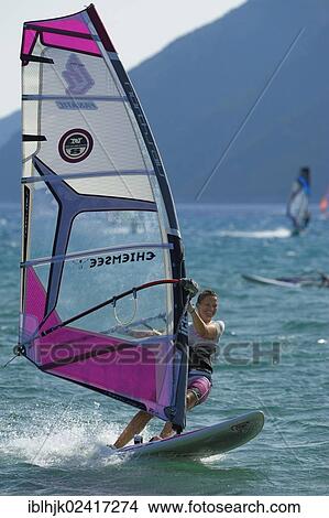 Female windsurfer surfing across the water on her board, Vassiliki, Lefkas, Greece, Europe View Large Photo Image Picture - Female windsurfer surfing across the water on her board, Vassiliki, Lefkas, Greece, Europe. Fotosearch