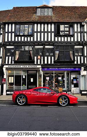 Stock Image - "Ferrari car parked in front of a half-timbered house, Stratford-upon-Avon, Warwickshire, England, United Kingdom, Europe". Fotosearch