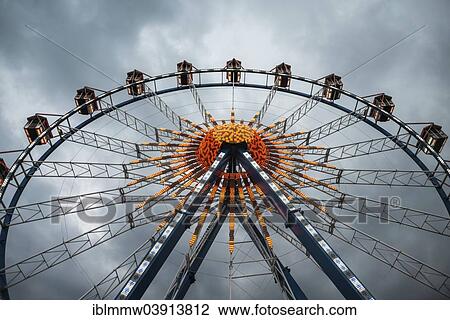 Stock Image - "Ferris wheel against dark clouds, Munich Spring Festival, Theresienwiese, Munich, Bavaria, Germany, Europe". Fotosearch