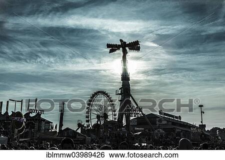 Stock Photograph - "Ferris wheel and fun rides in back light, Oktoberfest, Munich, Upper Bavaria, Bavaria, Germany, Europe". Fotosearch