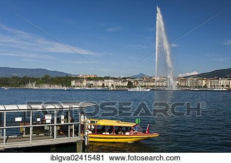 Stock Image - Ferry boat at the dock of the Geneva ferry company Mouettes genevoises in front of the giant fountain Jet d'Eau, with the snow-capped summit of Mont Blanc in France in the distance, Geneva, Switzerland, Europe. Fotosearch