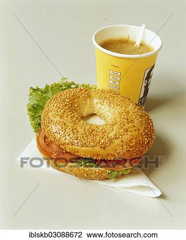 Stock Image - Filled bagel on a serviette and coffee in a paper cup. Fotosearch