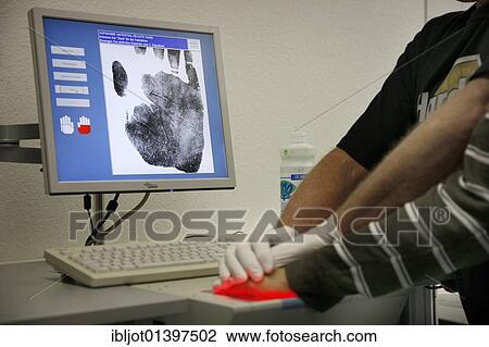 Stock Image - "Fingerprints and handprints being recorded by digital scanner, physical identification of a suspect in a criminal investigation by the Criminal Investigation Department, re-enacted scene". Fotosearch