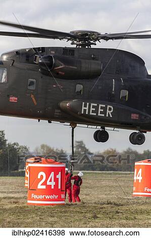 Firefighters hanging a 5000-liter water tank under a CH-53 helicopter of the German armed forces, during an exercise, Laupheim, Baden-Wuerttemberg, Germany, Europe View Large Photo Image Stock Photo - Firefighters hanging a 5000-liter water tank under a CH-53 helicopter of the German armed forces, during an exercise, Laupheim, Baden-Wuerttemberg, Germany, Europe. Fotosearch