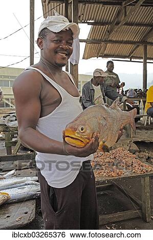 "Fisherman hoding a big fish in the fishing port, Limbe, Southwest Region, Cameroon, Africa" View Large Photo Image Stock Photograph - "Fisherman hoding a big fish in the fishing port, Limbe, Southwest Region, Cameroon, Africa". Fotosearch
