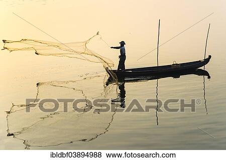 "Fisherman in a boat tossing out a net, morning light, Thaungthaman Lake, Amarapura, Mandalay Division, Myanmar, Asia" View Large Photo Image Stock Photo - "Fisherman in a boat tossing out a net, morning light, Thaungthaman Lake, Amarapura, Mandalay Division, Myanmar, Asia". Fotosearch