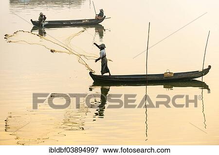 Stock Photo - "Fisherman in a boat tossing out a net, morning light, Thaungthaman Lake, Amarapura, Mandalay Division, Myanmar, Asia". Fotosearch